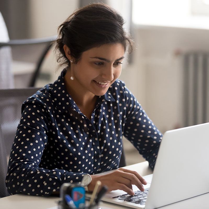 Student sitting at desk on her computer in the business program.