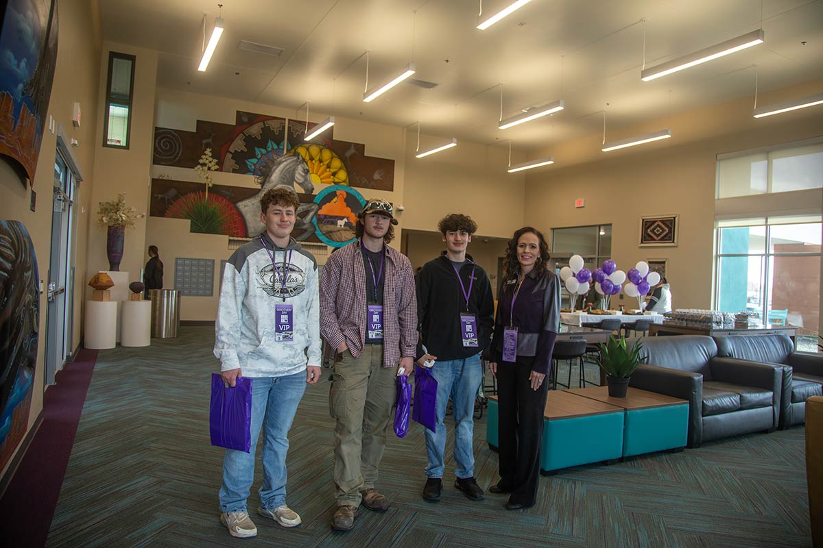 Three students standing with President of San Juan College in the dorms