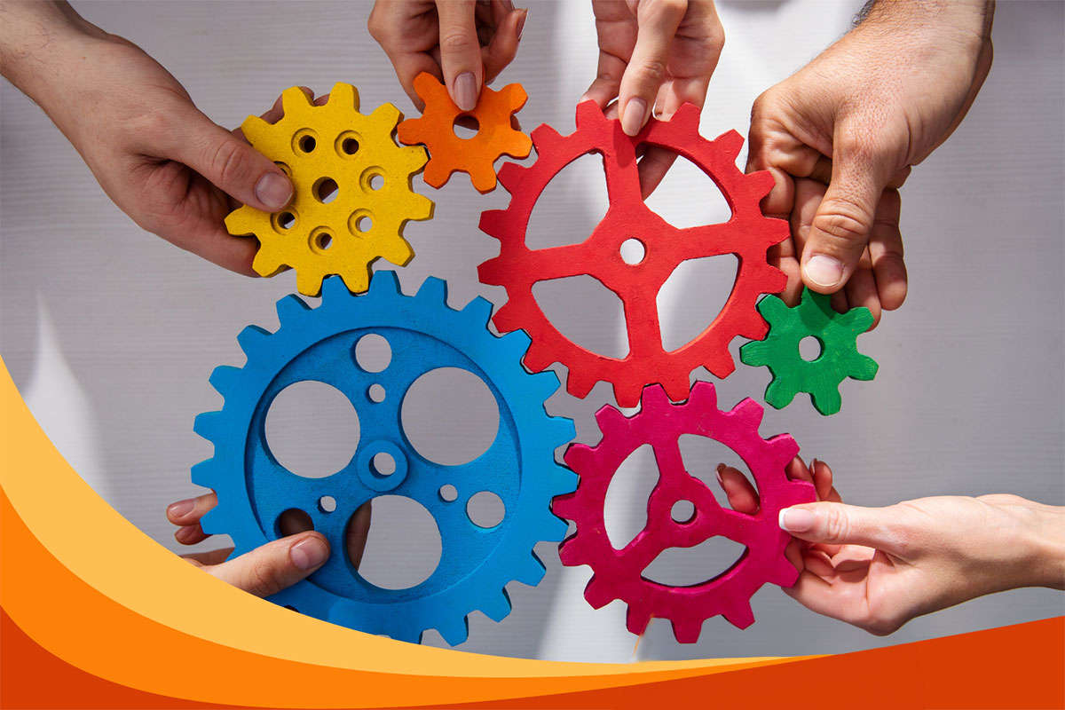 Hands holding various colored gears in their hands