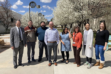 Brandon Fercik standing with Trio Center and KSJE Staff members