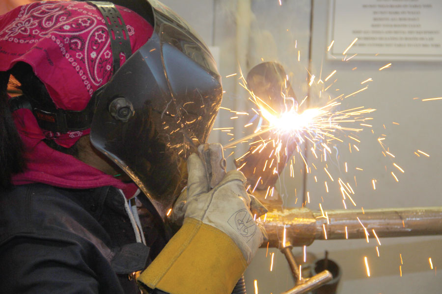 Welding student with sparks using welding torch