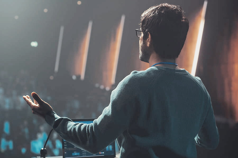 A speaker presenting to a crowd in an auditorium