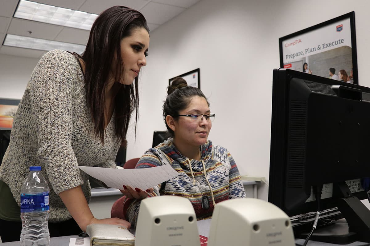 Two people looking at a computer screen.