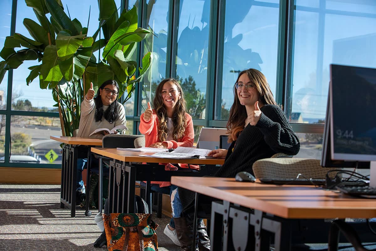 Students giving a thumbs up in the San Juan College Library.