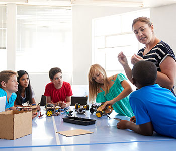 Teacher demonstrating program to five students.