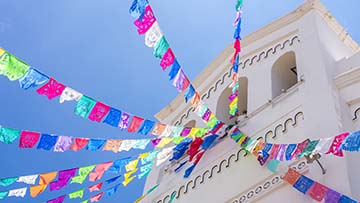 Multi-colored flags flying outside of building