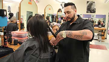 Cosmetologist cutting hair.