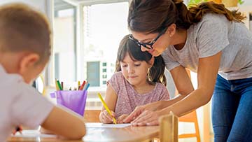 Teacher working with two children.