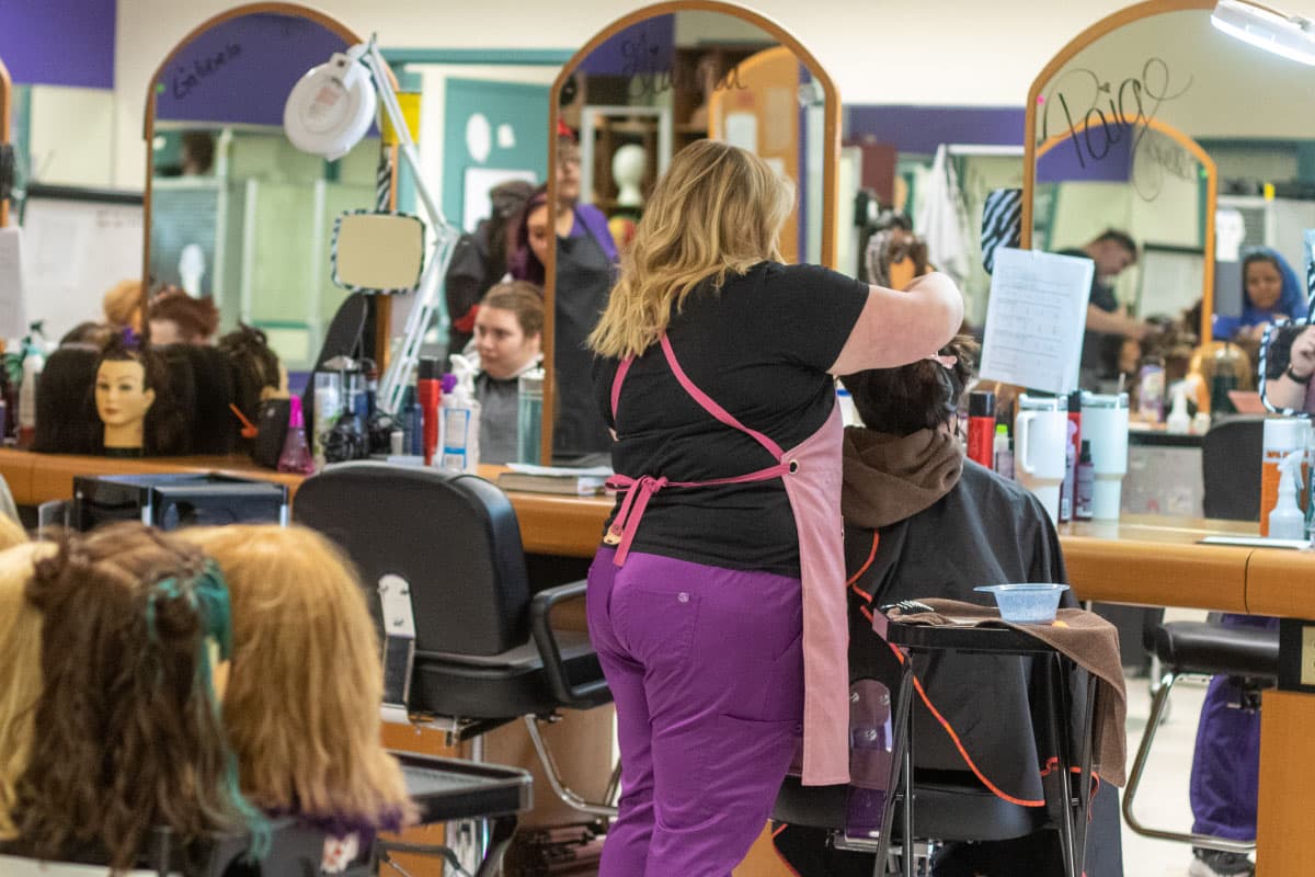 A San Juan College student giving a hair cut