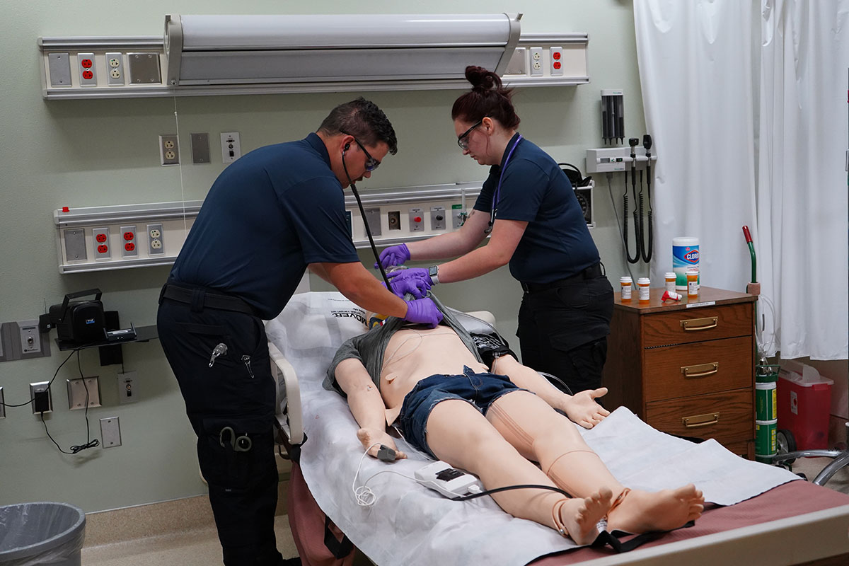 Students in the simulation lab intubating one of the small simulation dummies.