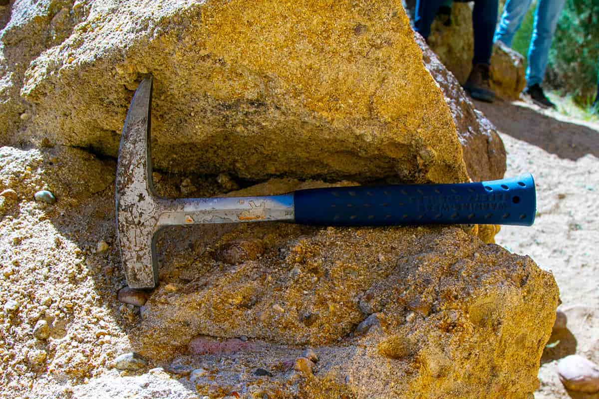 A pick axe sits on a boulder