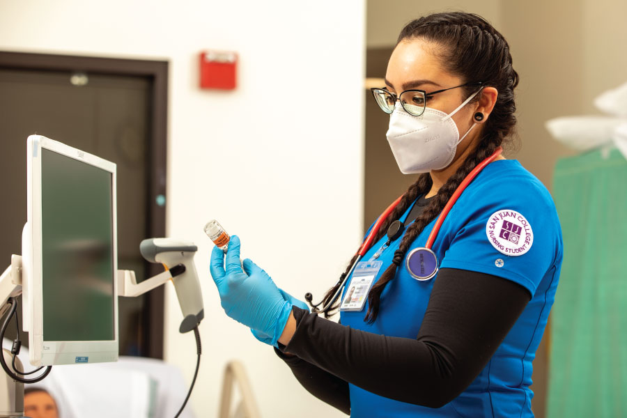 A San Juan College student learning medical equipment at the School of Health Sciences