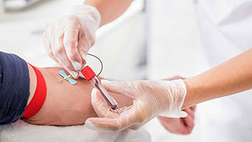 Person having blood drawn from arm.