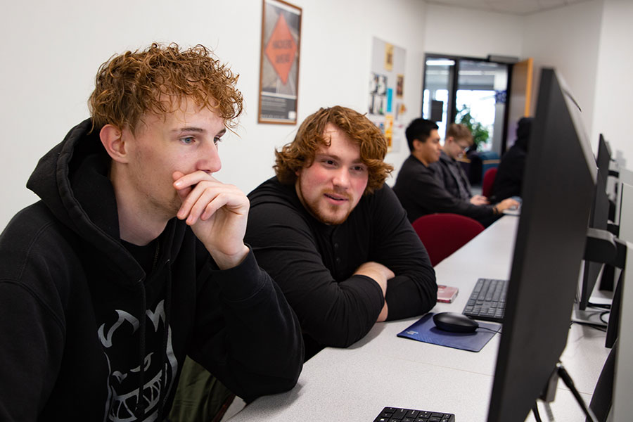 Two San Juan College students sit in front of a computer