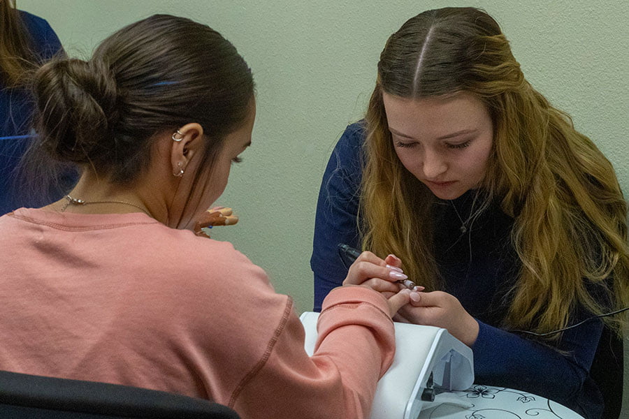 A San Juan College student giving a manicure