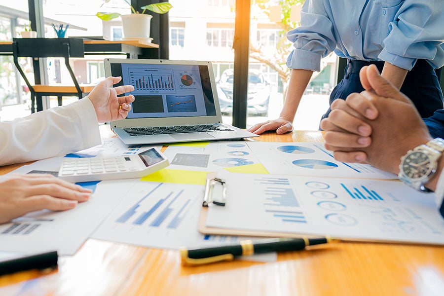 Marketing professional at a meeting looking at marketing charts on their computer.