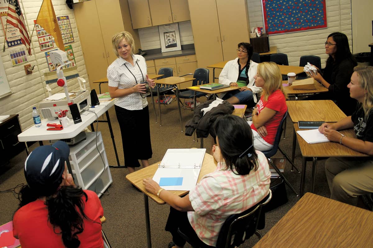 Pictured is an Instructor who got their degree in Teacher Education is instructing two students.