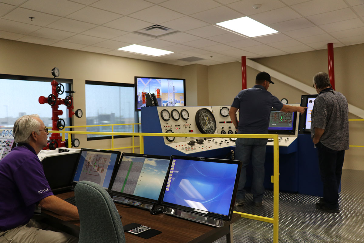 Three people in well control room.