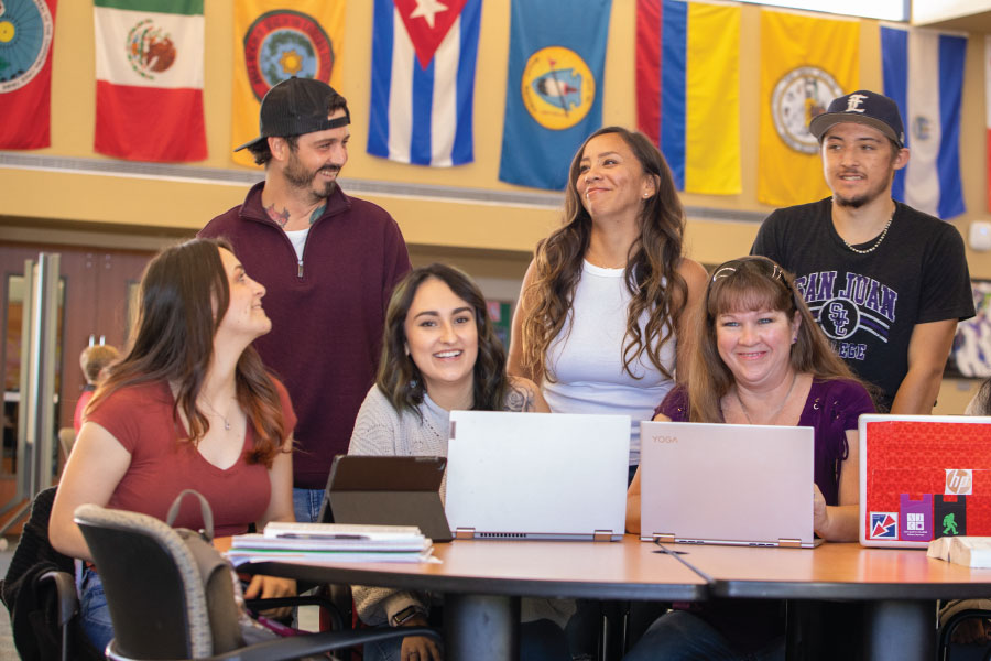 Grupo de estudiantes sentados en una mesa riendo