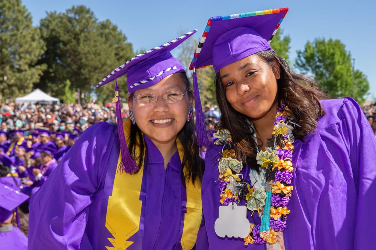 Two excited SJC graduates posing for a picture at Graduation