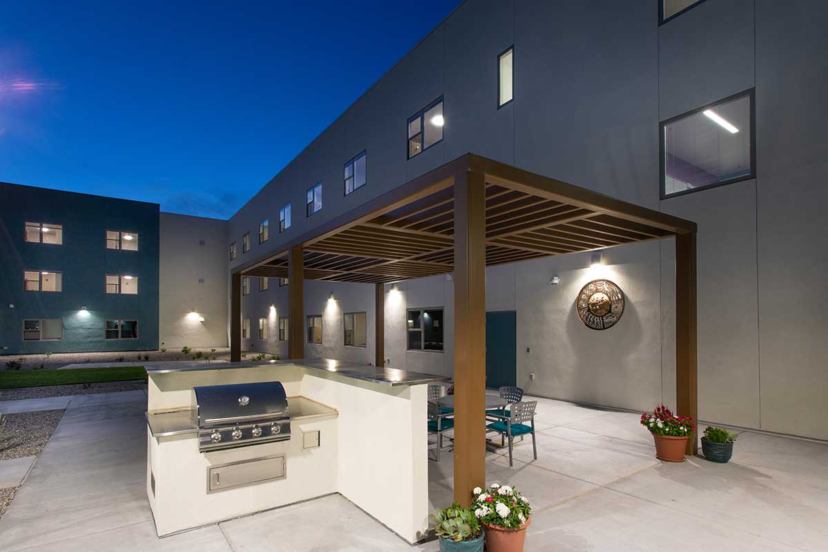 Back patio with outdoor spaces including grill and table at San Juan College Student Housing.