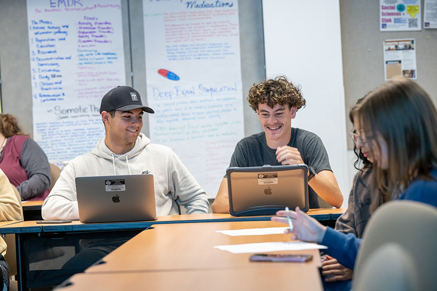 Students collaborating and using laptops in a community college class, illustrating that you can start college undeclared, explore options before choosing a major, and go to college without a major on day one.