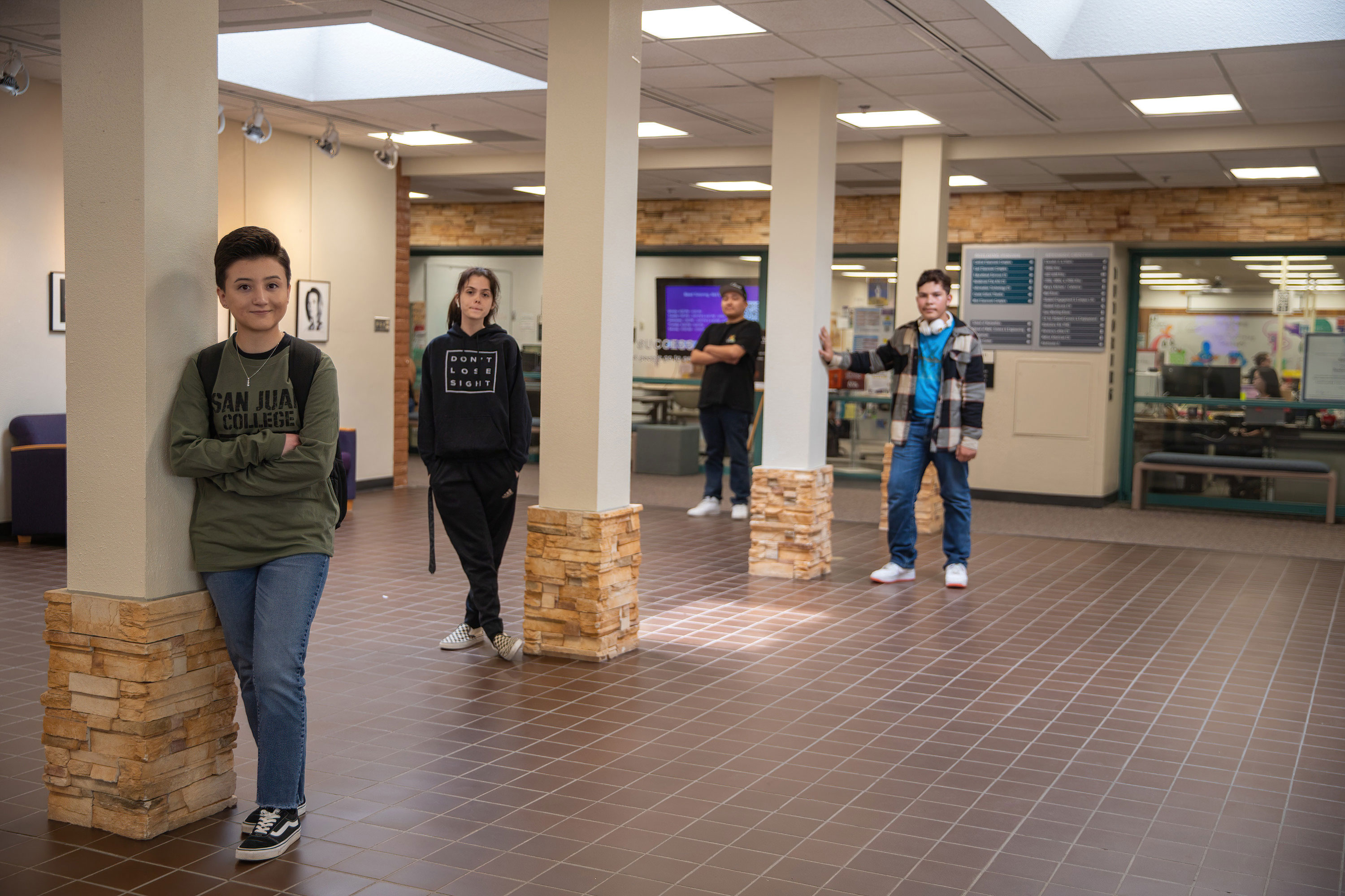 Four students standing by pillars in front of the SJC Tutoring Center