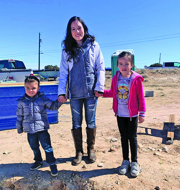 Mother with her two children standing hand-in-hand