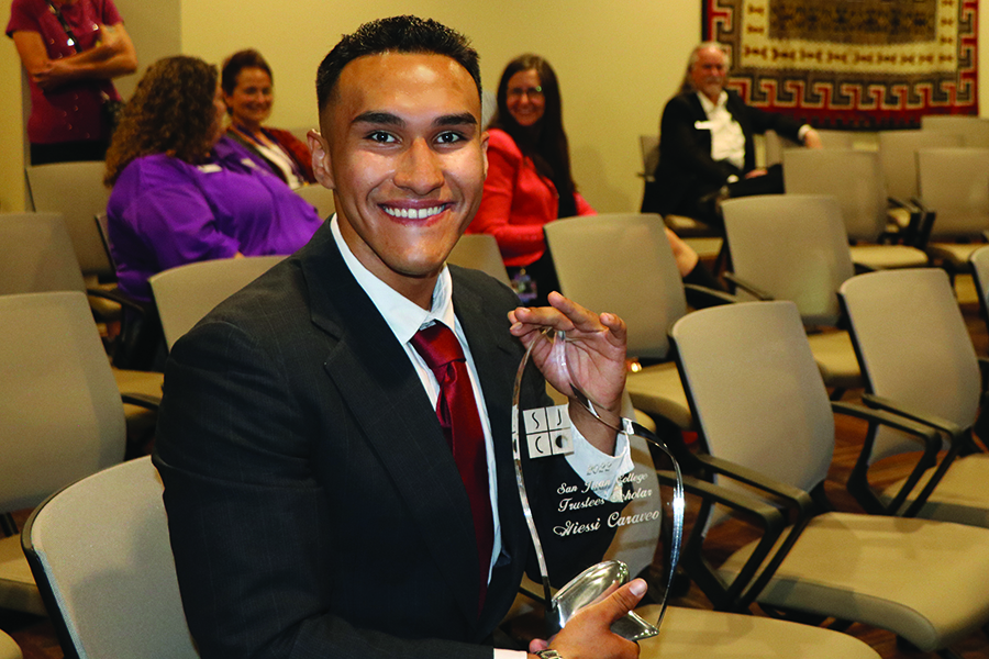 Scholarship winner holding a glass plaque