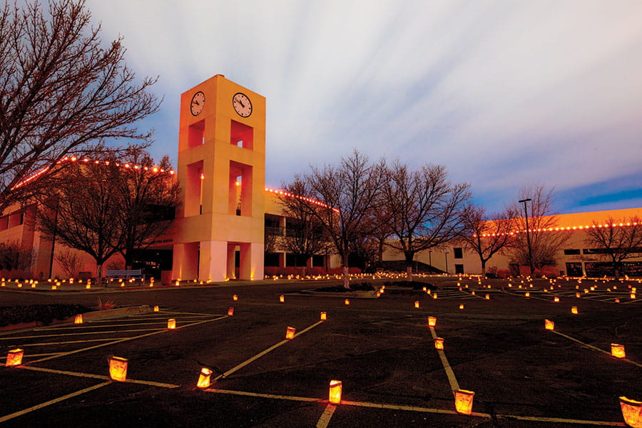 San Juan College clocktower with luminarias surrounding it.