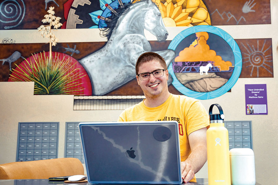 Student Nate Schirer sits at his computer in the SJC Housing.