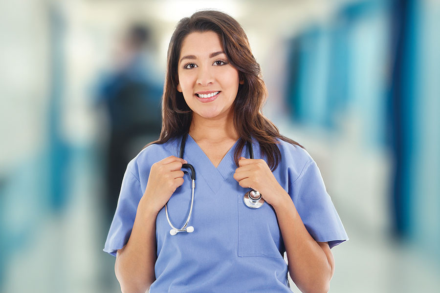 A San Juan College Medical Assistant student in blue scrubs with a stethoscope around her neck.